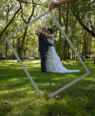 Les mariés photographié à travers un cadre en bois - photographe de mariage Ile-de-France